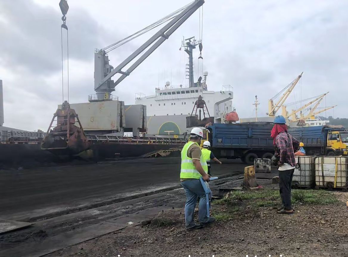 Surveyors performing utility detection with a cable locator at a port loading area
